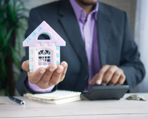 Imagen de un agente inmobiliario sosteniendo una casa